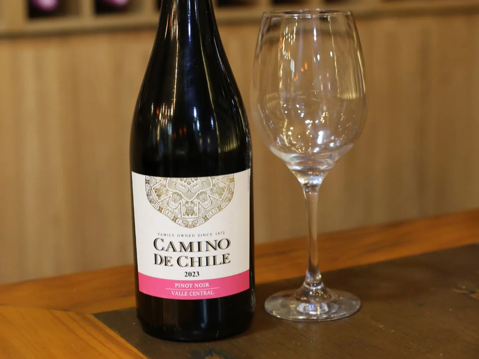 Garrafa de vinho tinto e taça sobre mesa de madeira no Nuboa Sushi