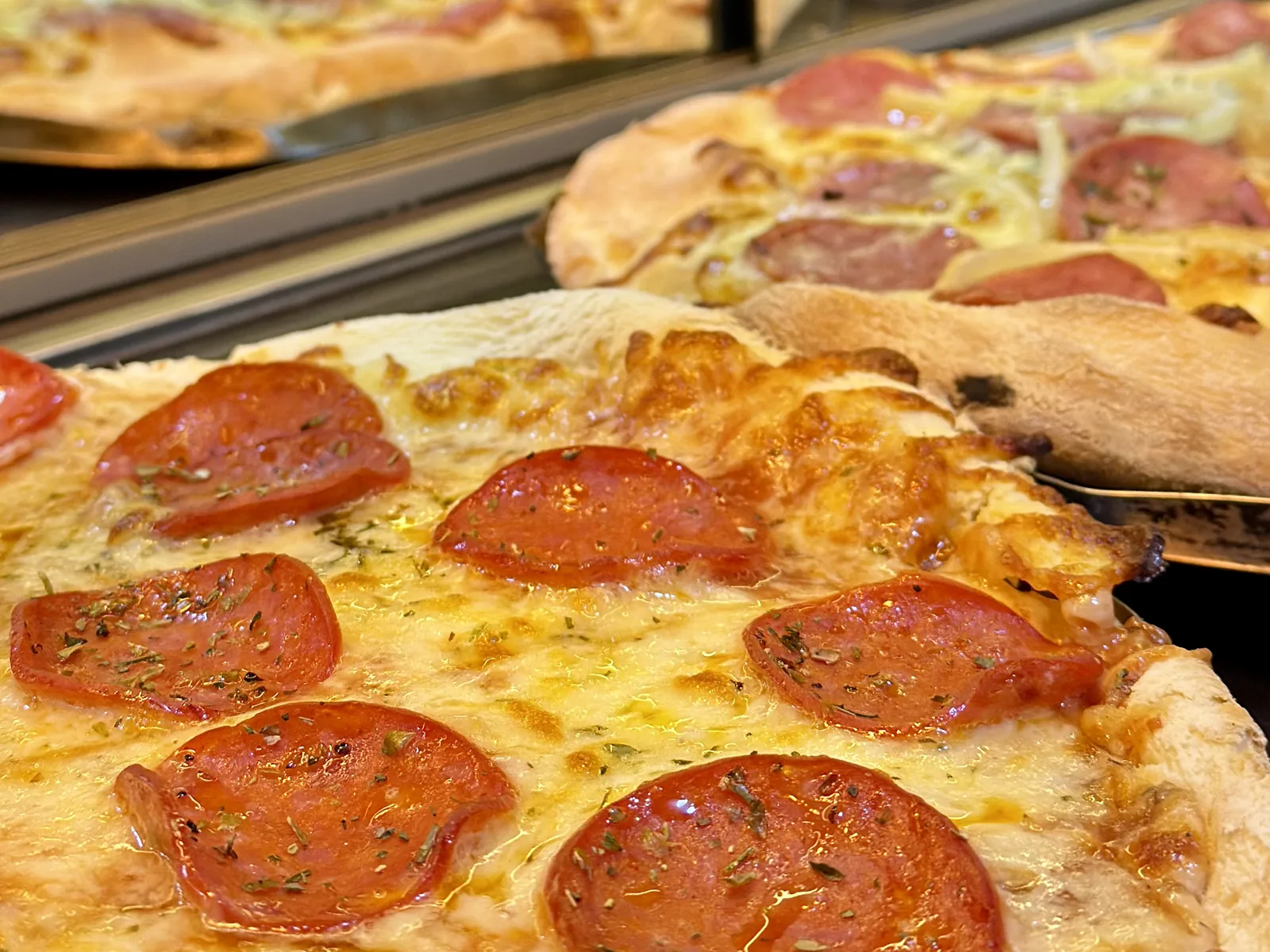 Fatias de pizza artesanal recém-assadas do rodízio de pizza do Nuboa Sushi